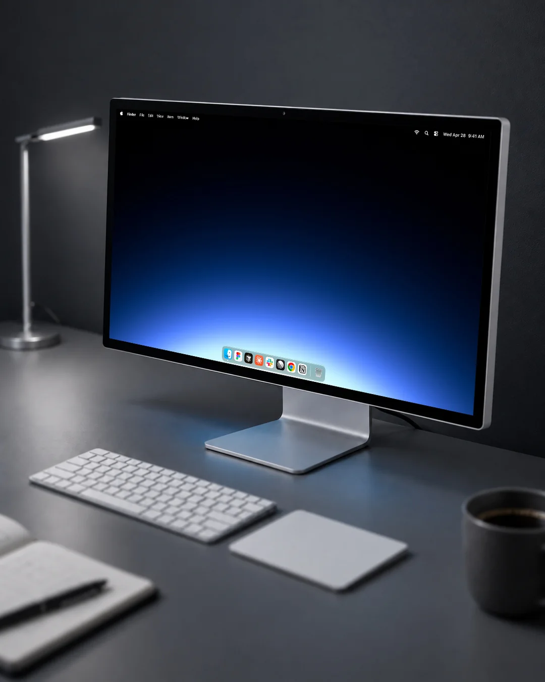 A Gradient wallpaper on a desktop display at a grey desk, a blue glow rising out of black